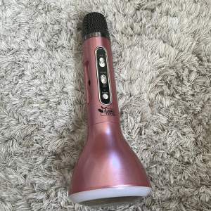 Säljer denna mikrofon i färgen rosa. Du kan välja led på den och höja eller sänka volym på den och välja om det ska vara echo. Du får med en laddare.