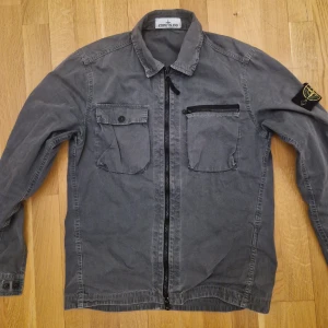 Stone island overshirt - Jag säljer en grå stone island overshirt i superbra skick. Äkta vilket kan verifieras med Qr kod. Skriv för frågor
