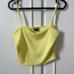 Linne med spagettiband - Gult linne med tunna band från Monki.  Aldrig använd.