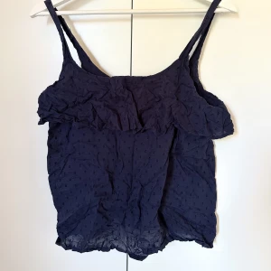 Blått somrigt linne - Fint marinblått linne med en volang upptill. Ej struken på bilden.  Säljer då jag aldrig använder det. Använt max tre gånger. 