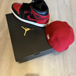 Jordan 1 - Säljer mina Nike Jordan 1 mid i nytt skick. Kepsen i storlek: 6 7/8 säljs också men ingår inte i priset.