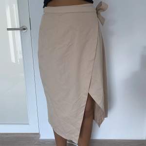 Beige kjol från Hanna Schönberg x NA-KD. Endast använd ett fåtal gånger och i bra skick. Modellen är 178 cm lång 🩵