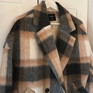 Skjortjacka - Ulljacka från Lindex, något fodrad. Storlek S, men ngt stor i storleken beroende på hur man vill ha den. Fint skick förutom att ullen blivit lite nopprig.