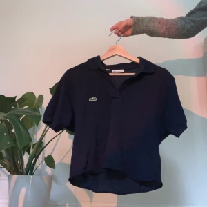 Lacoste pikétröja  - En jättefin marinblå pikétröja från lacoste som tyvärr inte kommer till användning längre. 