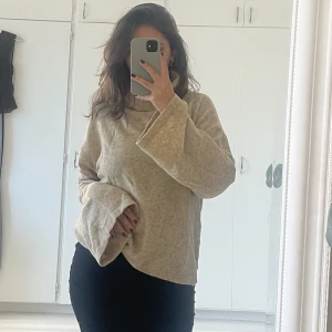 Stickad tröja  - En JÄTTEFIN stickad tröja med hög hals🤍✨ ganska tunn i materialet i en beige färg som drar liiiite åt det orangea hållet 🤍