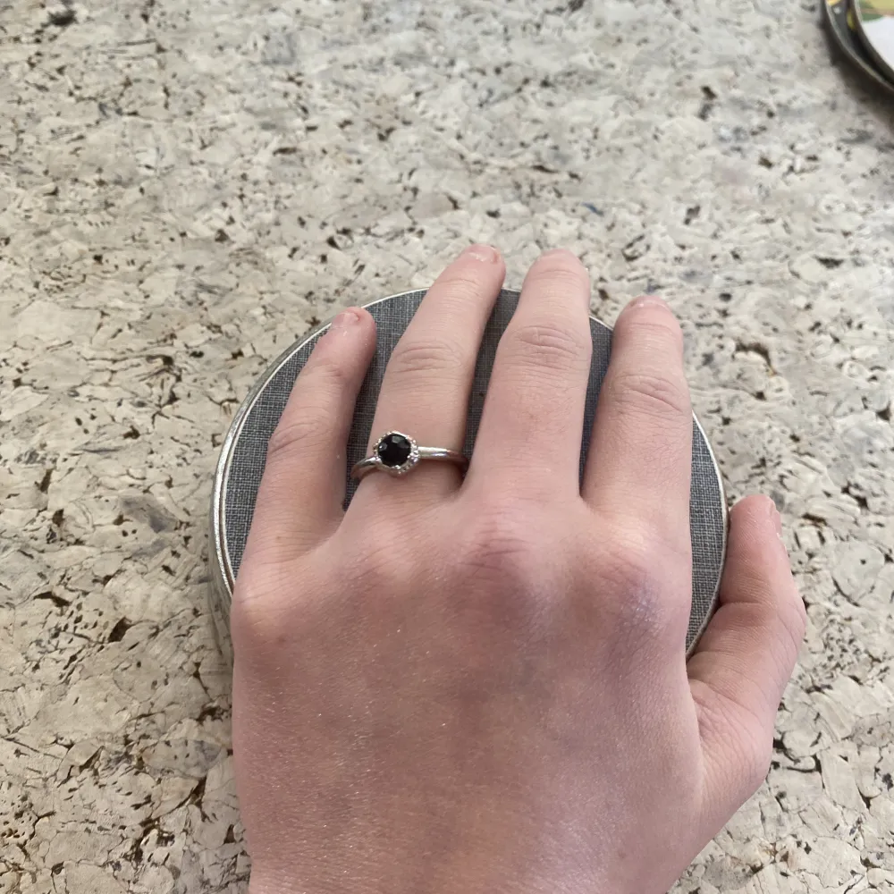 En silvrig ring med en svart glasdiamant 💎aldrig andvänd och väldigt fin.♥︎. Accessoarer.