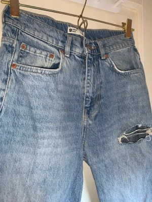 Mediumwash jeans - Bekväma, använda fåtal gånger, loose fit.  Tre hål, straight fit med något utsvänga längst ner. ’Normalmidjade’