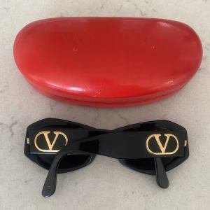 Valentino Garavani Solglasögon  - Säljer mina jättefina Solglasögon från Valentino. Sparsamt använda men texten på sidan har gått bort aningen. Köptes på vestiare och därmed gäller deras äkthetsgaranti. Skickar kvittot vid begäran. Skal medföljer 