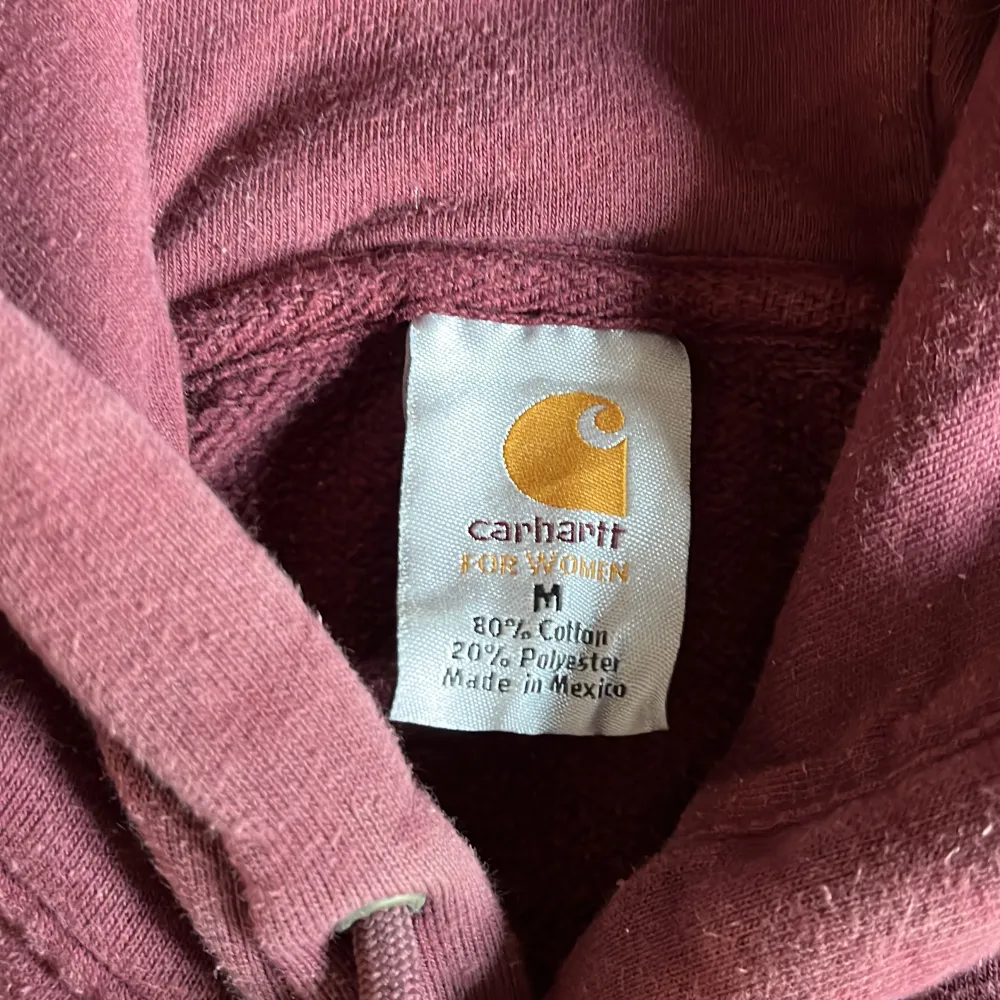 Vinröd Carhartt hoodie i storlek medium. . Hoodies.