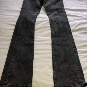 Lågmidjade bootcut jeans med slitning på låret. Innerbenslängd ca 80cm. Midjemått ca 70cm. Vikt ca 440g.