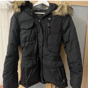 Hollies Livigno Jacka - Snygg och varm jacka, använd en säsong men fortfarande i super bra skick. Fuskpäls på luvan. 