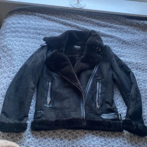 Fodrad bikerjacka - En aviator jacka/fodrad bikerjacka, helt ny aldrig använd storlek S men passar en M då den är lite översized. Pris kan diskuteras, köpt för 799 ett tag sen så är osäker om den fortfarande säljs, kan mötas upp i gbg eller frakta men köparen står för det.