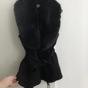 Joseph Ribkoff - väst  - Joseph Ribkoff - svart väst med svart pälskrage.   Väldigt snygg att bära som den är och även under jackan.   Köpt för några år sedan och är helt oanvänd.  Kvitto finns - köpt för 3300 kr. 