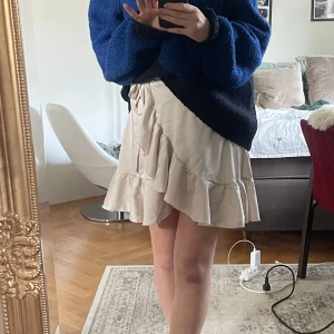 Volangkjol - En pärlvit volangkjol med rosett i sidan🌟 Måtten är: Midja (dock justerbar) - 29 cm Längd - ca 45 cm