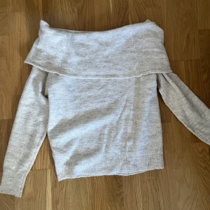 Stickad tröja  - En beige stickad of shoulder långarmad. Tröjan är tunn och lite genomskinlig. Aldrig använd då den är för kort i armarna. 