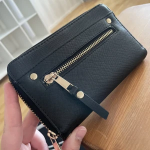 Plånbok - Svart plånbok med mycket utrymme. Fint skick.