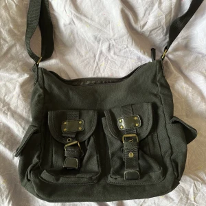 Svart väska - As snygg svart axelremsväska som man kan sjustera bandet på bra storlek och många fack, kom privat för fler bilder eller frågor :)