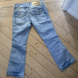 Lågmidjade jeans - Supersnygga och unika lågmidjade jeans i ljus tvätt. Modellen är utsvängd. Bra skick! Storleken motsvarar en M, midjemått 40 innerben 78❤️  KOLLA IN MIN PROFIL FÖR MASSOR AV ANDRA JEANS💞