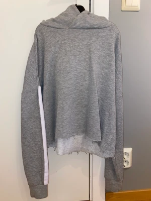Grå träningshoddie från Soc - En grå träningshoodie med uppriven underkant enligt designen. Den har även 2 vita sträck på ärmarna. Den är aldrig använd. Storlek S. Pris kan diskuteras