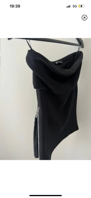 Svart topp med slits  - Super fin, lång fram och bak, får höfter 