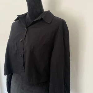 Svart skjorta  - Svart kort skjorta från H&M. Aldrig använd, nyskick.