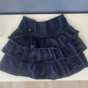 Marinblå volangkjol - Marinblå volangkjol köpt här på plick för två år sen och säljer vidare då den inte kommer till användning längre💞 Jag är 179cm lång och brukar ha S i kjol och skulle säga att den här passar S/M då tyget är stretchig🫶🏼