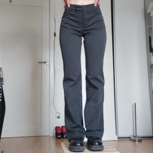 Grå kostymbyxor - Snygga grå kostymbyxor! Insydda i midjan där bak för att passa strl 36.  Är aningen långa på mig (169cm), men funkar fint med skor med lite sula. Pris går att diskutera vid snabb affär.