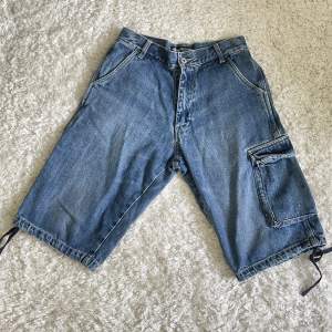 Snygga Stussy jeans shorts. Finns snören i benöppningarna som kan dras åt. Insida ben: 31cm Utsida ben: 57cm Ben öppning: 24cm 