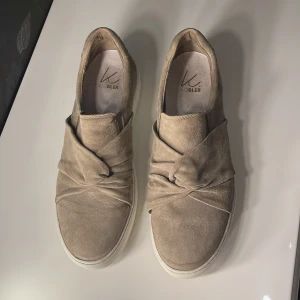 Beigea skor - Beigea skor med mockaimitation och knytdetalj. Inte jätteanvända men slitningar finns. Ca 3,5 cm hög sula. Storlek 40.