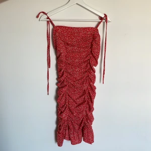 Röd klänning - Storlek S. Fin sommarklänning i fräsch röd färg. Ej använd.