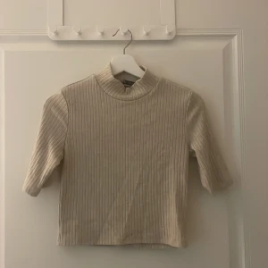 Ribbad kortärmad tröja  - Med en högre krage 