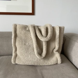 Stand studio väska ”LOLA” - Stor väska från stand i bouclé. Vit/ljust ljust beige i färgen. I använt skick men inget specifikt att anmärka på annat än den del på framsidan som ser lite tillplattad ut på bild 3 :-)