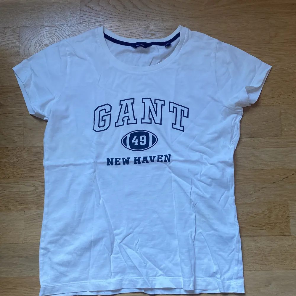 Vit Gant t-shirt i fint skick, nästan oanvänd men hyfsat gammal. På sidan ligger en liten gul/ grön fläck som nästan inte alls syns om man inte håller upp mot starkt ljus.. T-shirts.