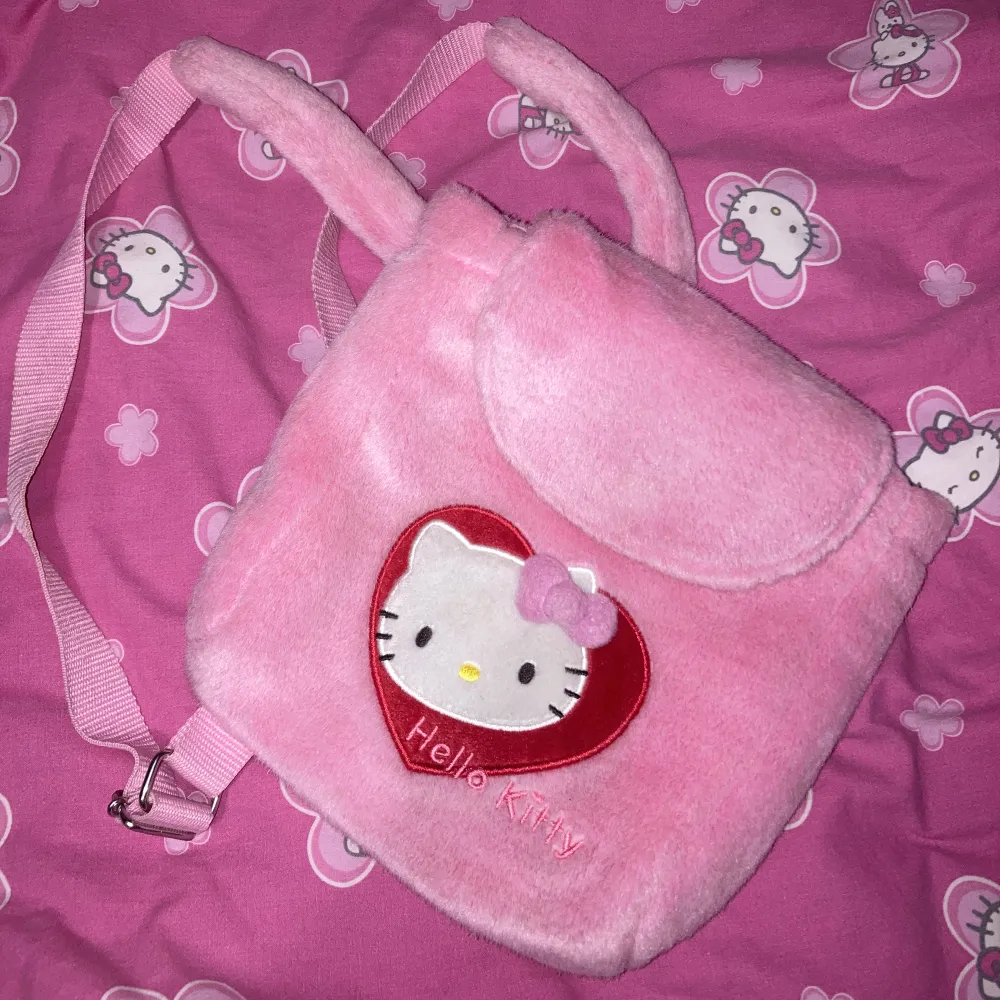 Rosa liten fluffig HK ryggsäck. Den är ca 25cm hög (Det är en ryggsäck för barn). Sanrio märkt! . Väskor.