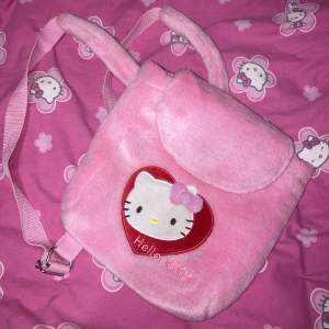 Rosa liten fluffig HK ryggsäck. Den är ca 25cm hög (Det är en ryggsäck för barn). Sanrio märkt! 