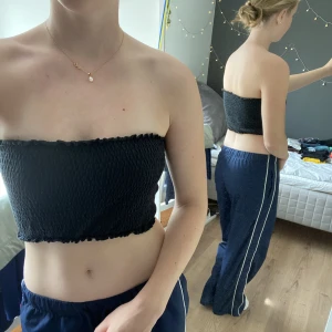 Svart Tube-Top - Svart, kroppad tight tube top från soc köpt på stadium. Är egentligen en bikini men jag har använt som topp. Sånt här ribbad elastiskt material. Använd ca 10 gånger. Sitter på väldigt bra och har aldrig ramlat ner på mig! Org pris 75 kr.