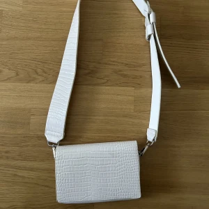 Carin Wester väska - Säljer denna vita axelremsväska från Carin Wester då den inte kommer till användning längre. Den är använd fåtal ggr och är i bra skick! 😁