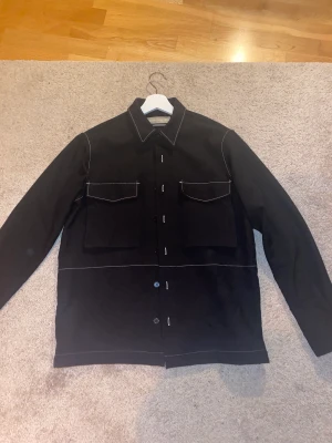 Adnym Atelier Skjorta - Tja! Säljer en riktigt nice skjorta från Adnym i svart färg med vita detaljer i sömmarna. Nypris 1600. Storlek S men sitter som en M. Den är använd fåtal gånger och är helt utan skador eller liknande.