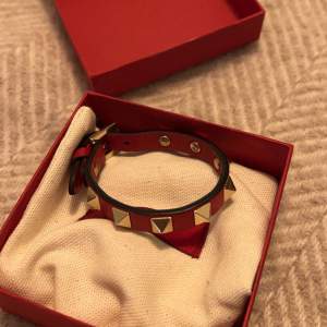 Rött unikt valentino-armband med guldnitar som är i superbra skick. Köpt på NK i Stockholm. Kvitto, dustbag, äktehetsbevis och box medföljer. Nypris idag är ca 3000kr. Armbandet är i väldigt gott skick och har inga tecken på slitage. Skriv vid frågor ❤️‍🔥❤️‍🔥❤️‍🔥