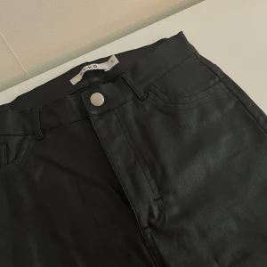 Byxor i läderimitation  - Byxor från NAKD i läderimitation. Medelhög midja  Exklusive frakt 