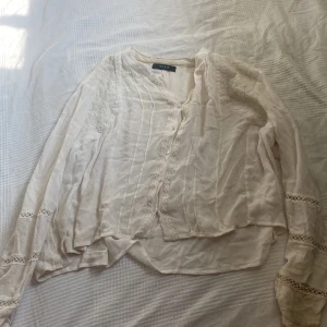 Blus  - En blus med mycket mönster. Man ser inte igenom men om man har en start färg under det man. Den passar S fast den är M