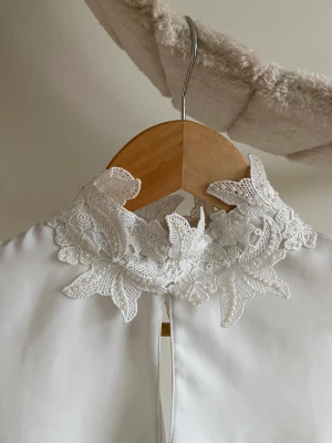 Vitt linne med pärlkrage - Hund och katt finns i hemmet.