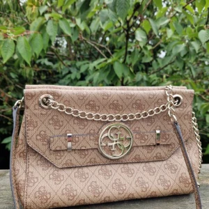 GUESS väska  - Snygg axelremsväska från GUESS i fint skick. Det finns någon liten fläck i innefodret, men ingenting som stör. 26cm bred, 19cm hög, 8cm djup. Väskan stängs med en magnetisk knapp och inuti finns flera fack i olika storlekar. Nypris 1500 säljer för 600.