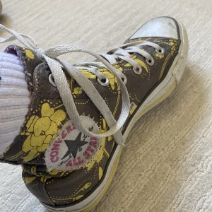 Converse skor  - Bruna converse med gula blommor och rosa insida i storlek 37. Använda men utan defekter+ går att tvätta rena