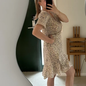 Neo noir omlottklänning - Omlottklänning från Neo Noir. Som ny, sparsamt använd. I storlek M, men passar mindre och större storlekar då man själv justerar den i midjan.   Nypris: 899:-