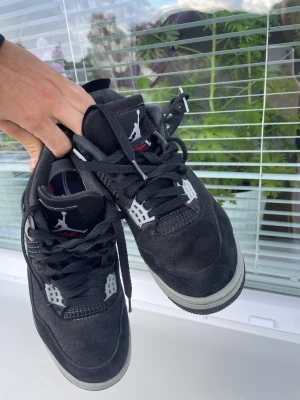 Jordan 4 Retro skor svart - Skor, stl. 41, Herr Svarta Jordan 4 Retro - Perfekt skick, säljs då de är en storlek för liten.  Dessa svarta Jordan 4 Retro-skor är i perfekt skick och kommer verkligen att imponera på sneakerälskare. Tyvärr blev de en storlek för liten för mig.