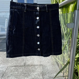 Jeans kjol från ginatricot - Söt jeanskjol från ginatricot med knappar framtill. Använd en del men inga defekter😊