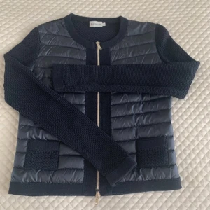 Moncler cardigan  - Säljer denna marinblå Moncler cardigan då den tyvärr är förliten på mig. Jackan är i storlek S och är perfekt inför sommaren. Kvitto finns ej då jag fick den i present. Den är i bra skick Ej säker på om jag vill sälja jackan, men buda:)