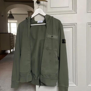 Stone Island zip hoodie - Säljer denna feta Stone Island zip hoodie i juniorstorlek 170 | Nypris: 2800 | Budgivningen startar på 100 kr | Skick: 8.5/10 har använt denna fåtal gånger | Hör av er vid minsta fråga eller fundering :)