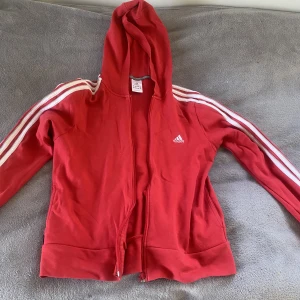 Röd adidas jacka  - En fin röd adidas jacka i storlek 42.  Köpte för 250kr på sellpy! Priset kan diskuteras 🫶🏻Jackan är i bra skick  